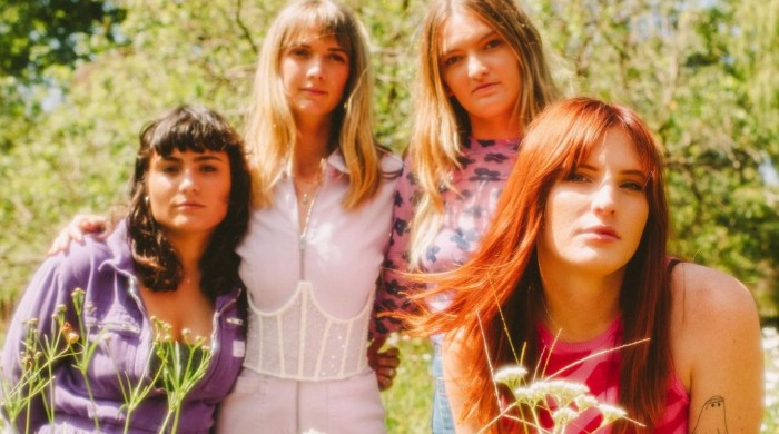 Four woman dressed in pink & purple in a field